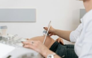 A healthcare professional performs an ultrasound on a pregnant woman in a clinic.